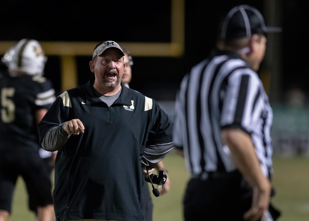 Panthers head coach Harry Lees has a conversation with a referee during the Pine Forest vs Milton football game at Milton High School on Friday, Oct. 15, 2021.