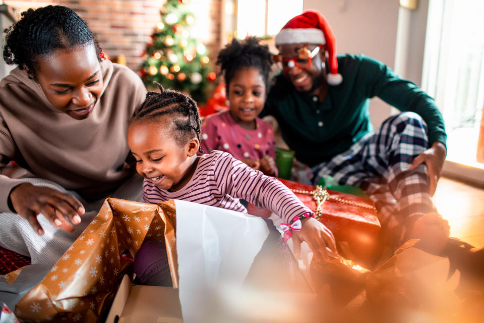 Close up of a young family opening their presents on Christmas morning. (Getty Images)
