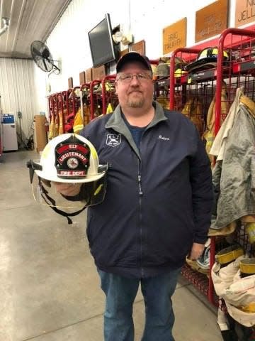 Anamosa State Penitentiary corrections Officer Robert McFarland, who also served as a lieutenant with the Ely Fire Department, holds his department helmet in an undated family photo. McFarland was killed during an attempted prison breakout on March 23, 2021.