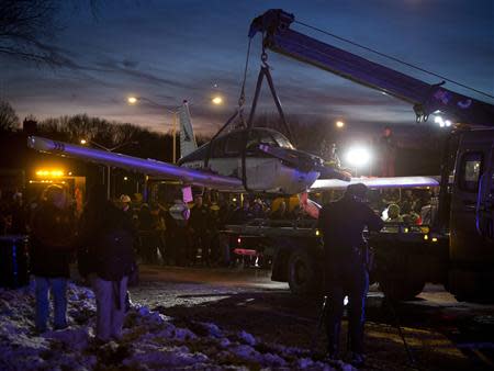 A single engine plane is lifted onto a flat bed truck after landing on Major Deegan Expressway in the Bronx borough of New York