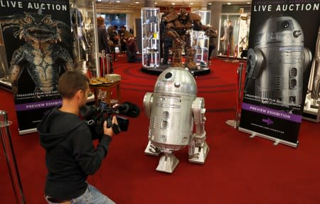 A journalist films a R2-BHD Droid which featured in "STAR WARS: ROGUE ONE: A STAR WARS STORY (2016)" at a preview of a film and tv memorabilia sale in London