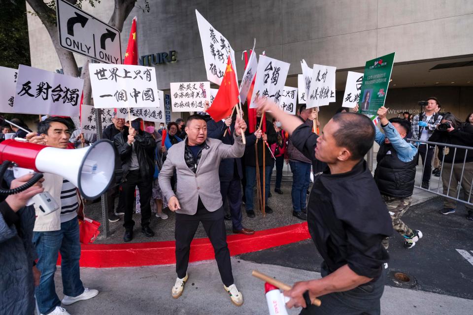 Supporters of Taiwan, right, confront protesters opposed to Taiwanese independence outside a hotel where Taiwanese President Tsai Ing-wen is expected to arrive in Los Angeles, Tuesday, April 4, 2023.