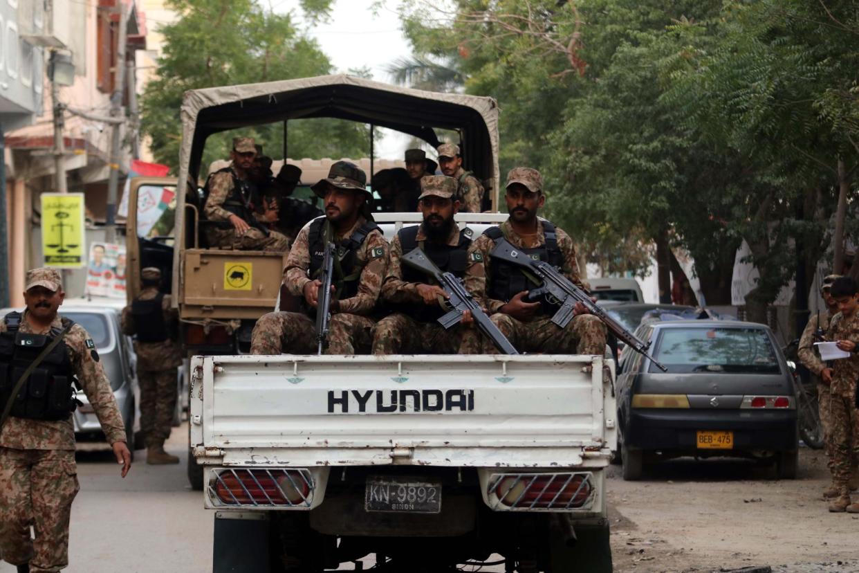 <span>Soldiers patrol near a polling station on election day in Pakistan.</span><span>Photograph: Rehan Khan/EPA</span>