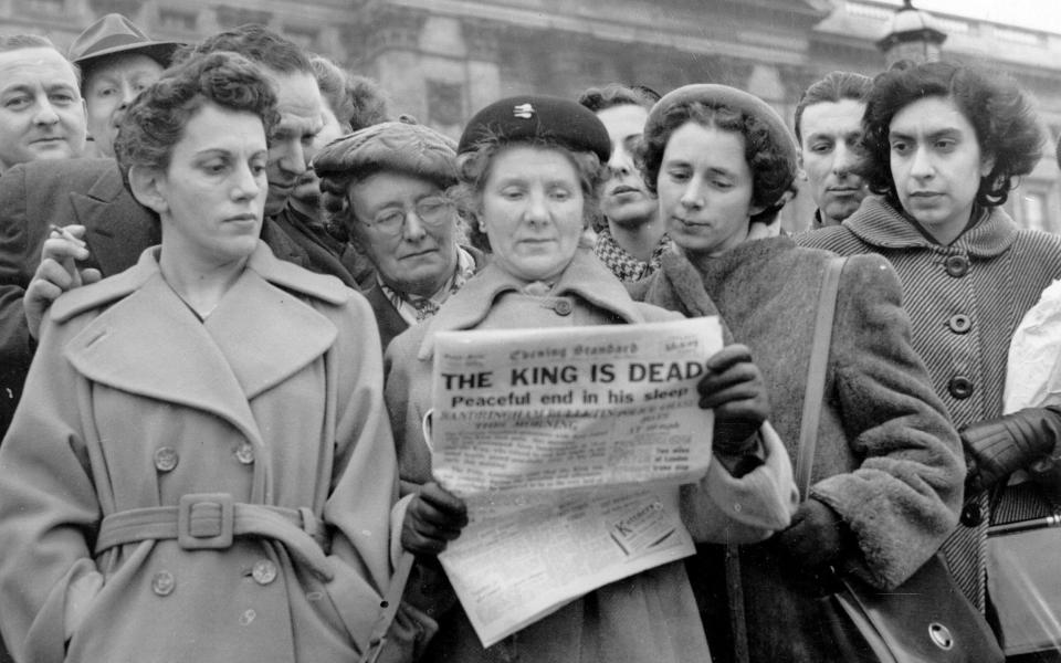 Crowds outside Buckingham Palace, London, read the news in the Evening Standard that King George VI had died at Sandringham on February 6 1952