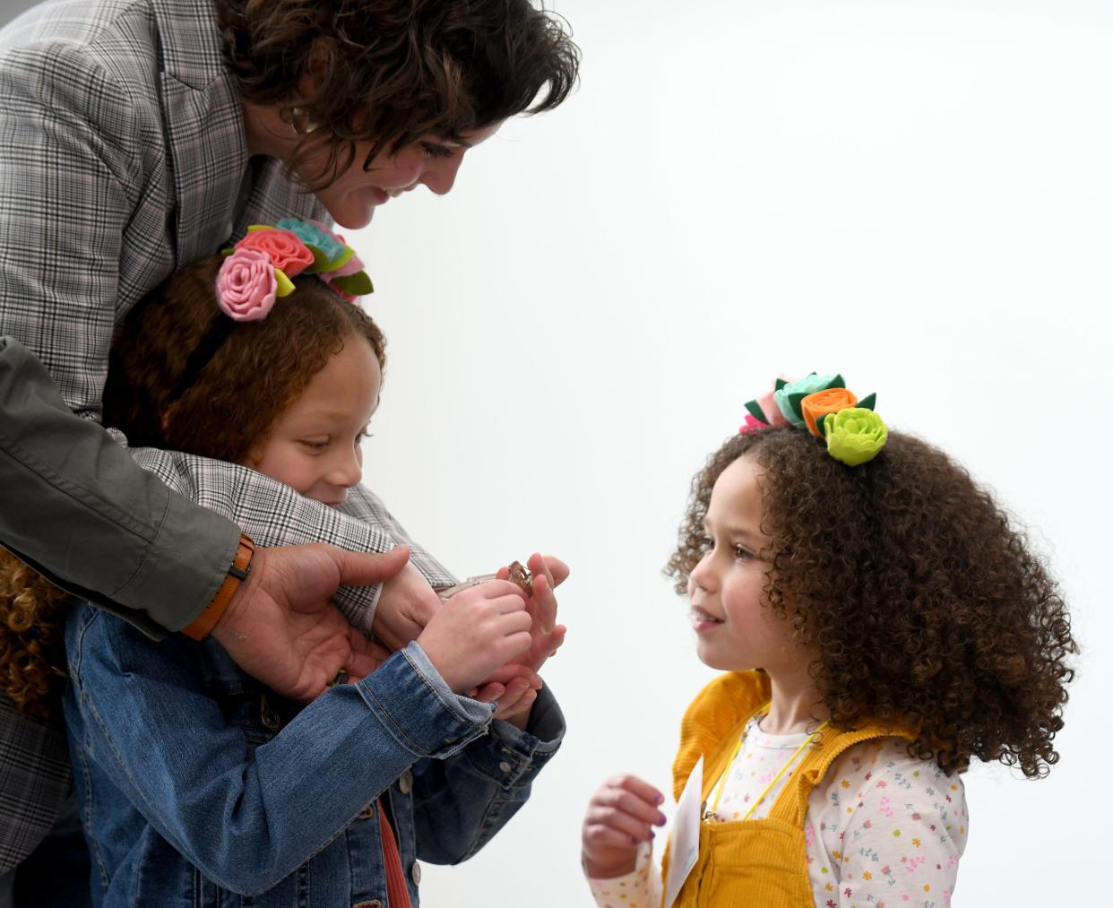 Marjorie Tyson, with daughters Cadence, 7, and Nora, 5, get a good look at the keys to their new home in Plain Township. Habitat for Humanity, Charis Homes and Saint-Gobain officially turned over keys Wednesday to the Tyson family.