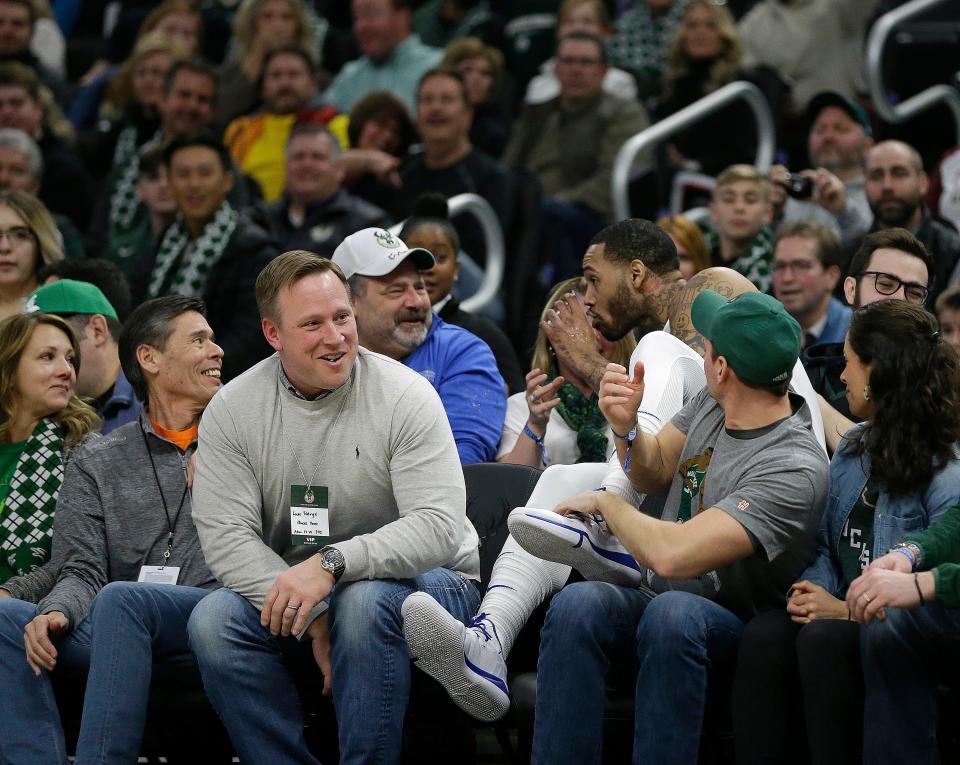 Philadelphia 76ers' Mike Scott takes a sip of a fan's drink after diving into the stands for the ball during the first half of an NBA basketball game against the Milwaukee Bucks, Sunday, March 17, 2019, in Milwaukee. (AP Photo/Aaron Gash)