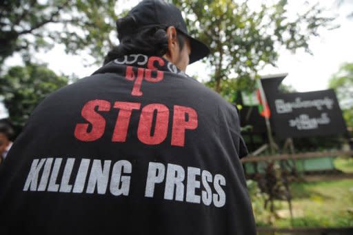 A Myanmar journalist wears a T-shirt reading 'Stop killing press' as he waits outside a court for a ruling on a defamation case against 'The Voice Weekly' in Yangon on August 23, 2012. The mining ministry filed a criminal defamation suit against The Voice Weekly, which reported that the auditor-general's office had discovered misappropriations of funds and fraud at the government division