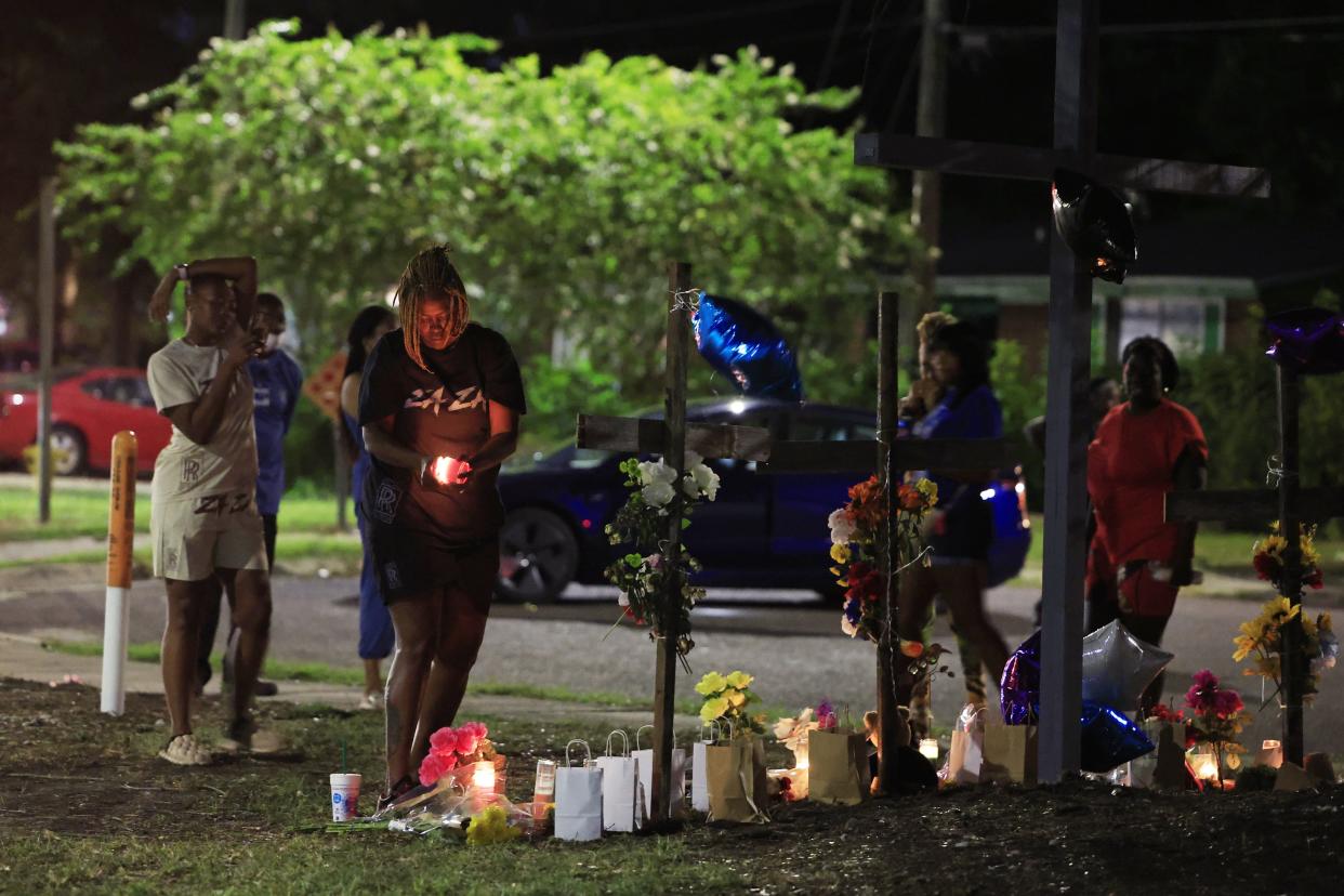 Mourners pay their respects at a vigil constructed with crosses and a mural at Almeda Street and Kings Road in Jacksonville. Two days earlier, a white gunman shot and killed three Black victims at the Dollar General store about a block away.