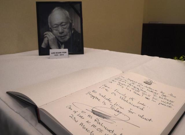 A portrait of Singapore's first prime minister Lee Kuan Yew on display next to a book of condolence at the Singapore High Commission in Kuala Lumpur, on March 23, 2015
