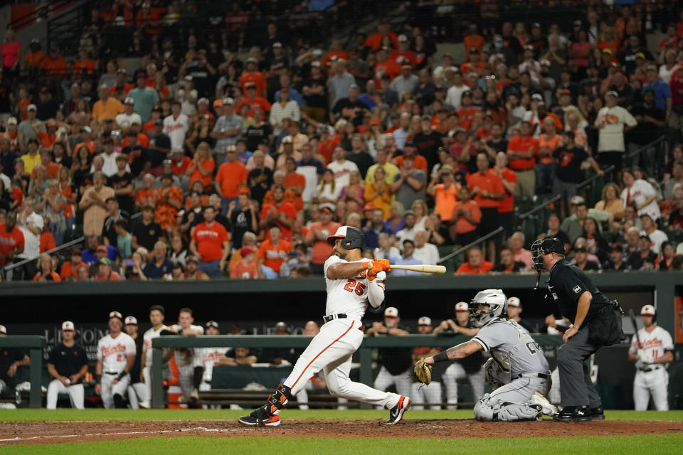 Baltimore Orioles' Anthony Santander (25) follows through on a swing while hitting a bases-loaded double off Chicago White Sox relief pitcher Aaron Bummer during the seventh inning of a baseball game, Tuesday, Aug. 29, 2023, in Baltimore. Orioles' Ryan McKenna, Adley Rutschman and Gunnar Henderson scored on the double. (AP Photo/Julio Cortez)