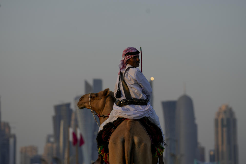 Un guardia monta su camello en las afueras del Amiri Diwan, las oficinas del emir de Qatar en Doha, el domingo 27 de noviembre de 2022 (AP Foto/Natacha Pisarenko)