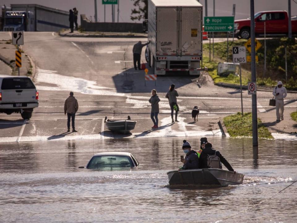 People are transported on a boat after being rescued from an area that was cut off due to flooding in Abbotsford, B.C. on Nov. 16, 2021. Experts say eco-anxiety is increasing as British Columbians witness and experience extreme weather, from the summer's forest fires and heat dome, to recent floods. (Ben Nelms/CBC - image credit)