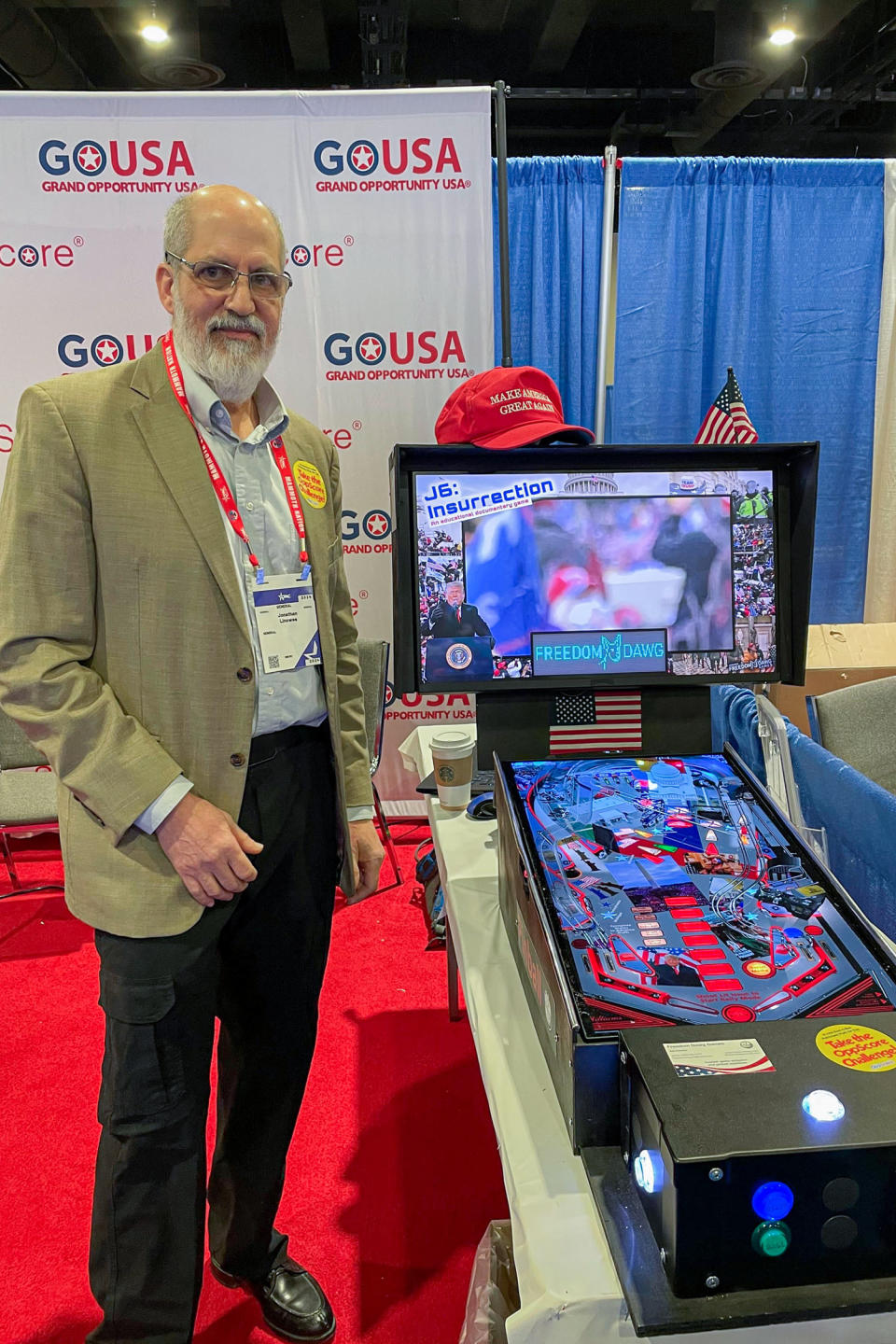 Jonathanan Linowes with his Jan. 6-themed pinball machine on display at CPAC. (Benjamin Goggin / NBC News)