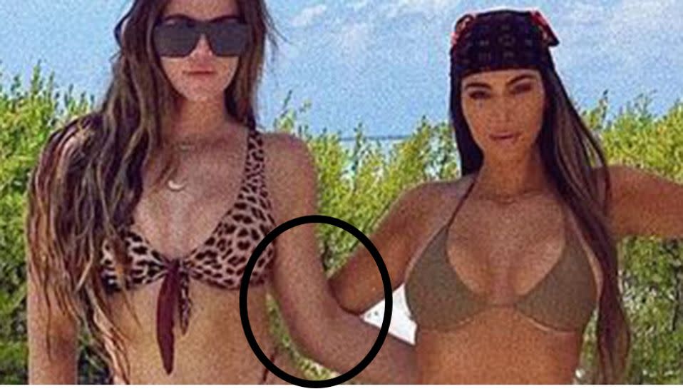 Kim Kardashian and Khloe Kardashian wearing bikinis on the beach