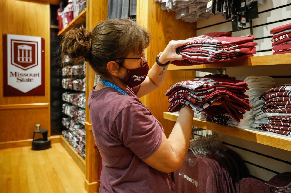 Becky Sullins straightens up T-shirts at the Missouri State University Bookstore.