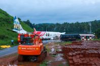 A man walks near the wreckage of an Air India Express jet at Calicut International Airport in Karipur, Kerala, on August 8, 2020. - Fierce rain and winds lashed a plane carrying 190 people before it crash-landed and tore in two at an airport in southern India, killing at least 19 people and injuring scores more, officials said on August 8. (Photo by Arunchandra BOSE / AFP) (Photo by ARUNCHANDRA BOSE/AFP via Getty Images)