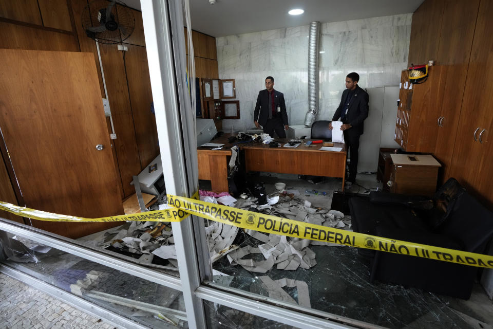 Agents inspect a security room that was trashed inside Planalto Palace, the office of the president, the day after it was stormed by supporters of Brazil's former President Jair Bolsonaro in Brasilia, Brazil, Monday, Jan. 9, 2023. The protesters also stormed Congress and the Supreme Court. (AP Photo/Eraldo Peres)