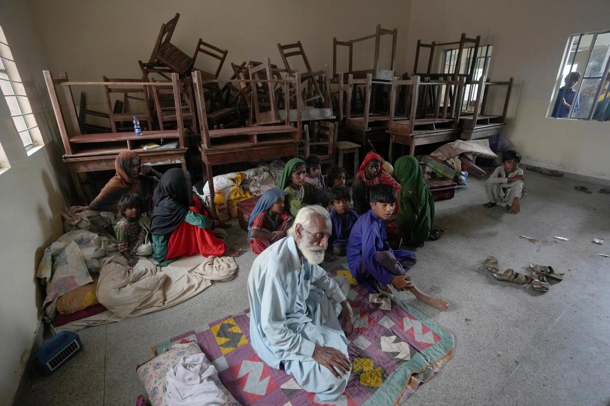 Families take shelter in a school after fleeing from their villages of costal areas due to Cyclone Biparjoy approaching, in Gharo near Thatta, a Pakistan's southern district in the Sindh province (AP)