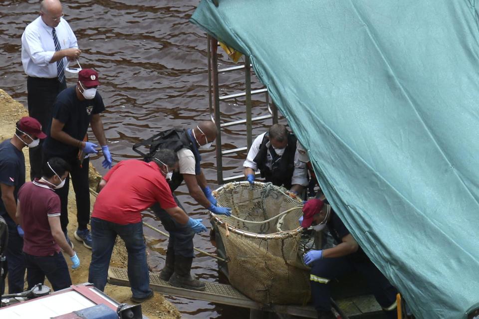 Cyprus Special Disaster Response Unit and investigators transport a suitcase from a boat (AP)