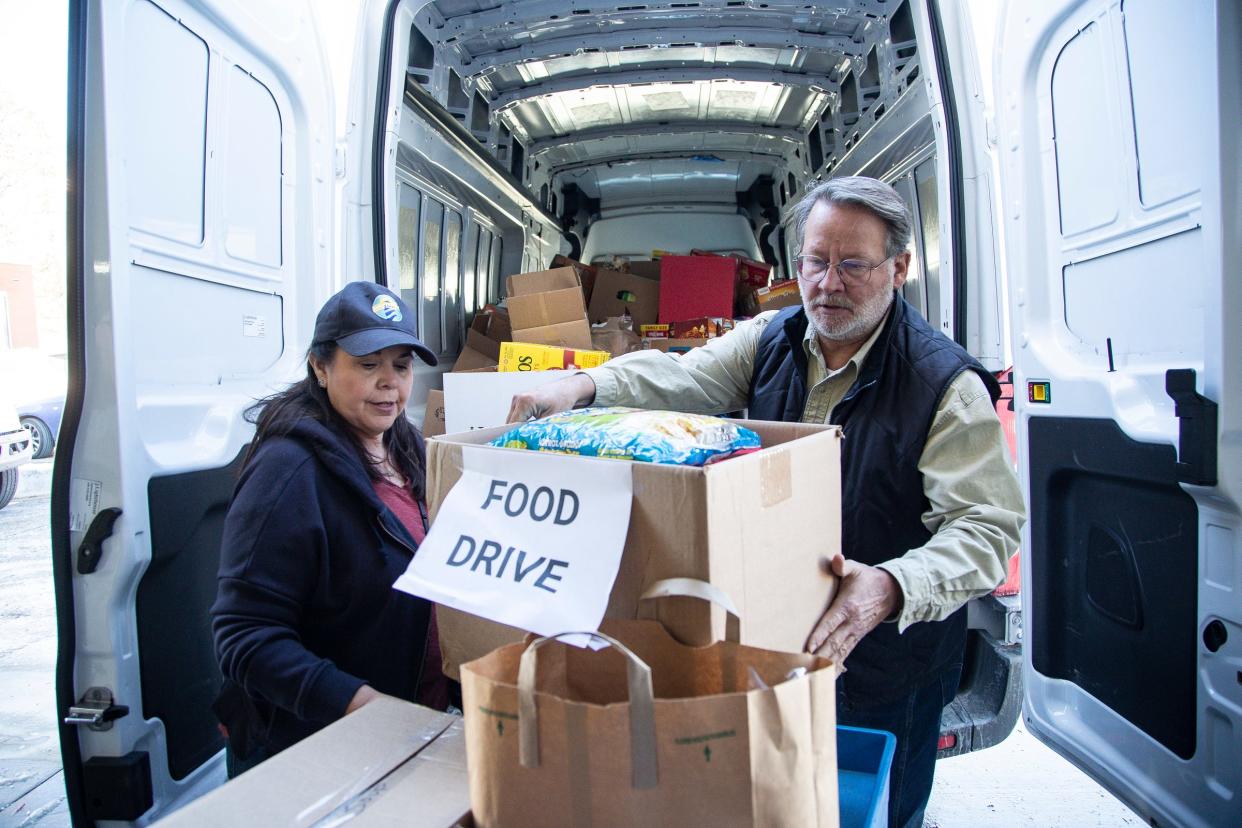 U.S. Senator Gary Peters and his wife Colleen Peters help unload a van full of donated food at the Lighthouse Emergency Services warehouse in Pontiac on Tuesday, Nov. 22, 2022.