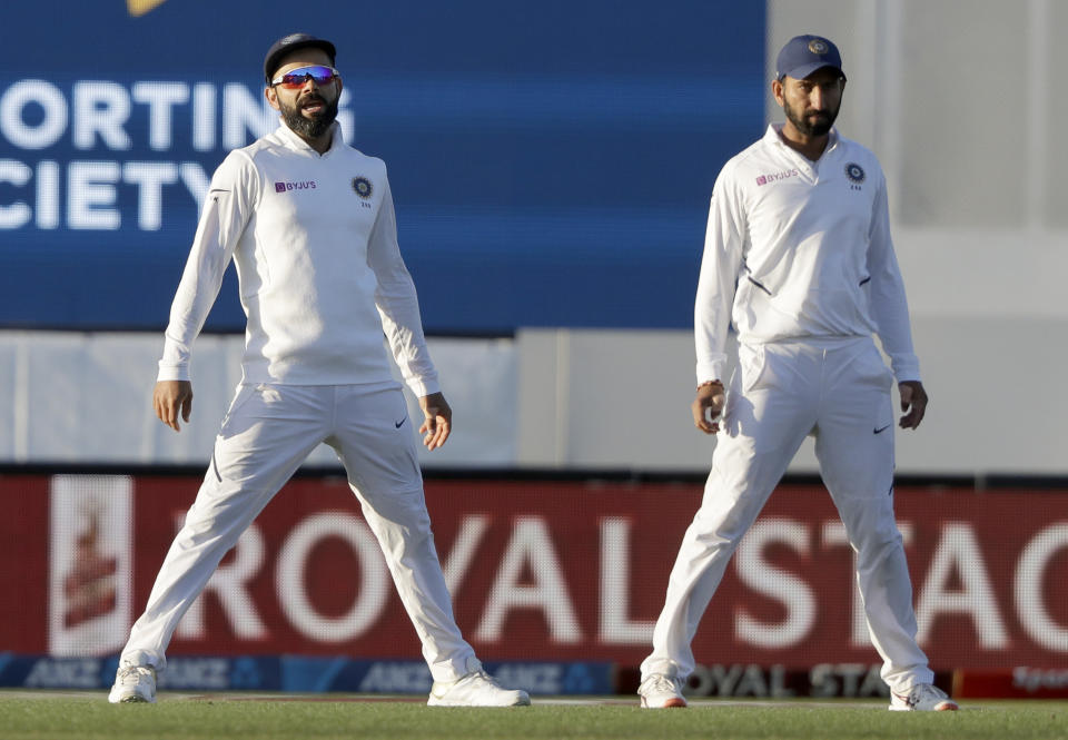 India's Virat Kohli, left, stands with teammate Cheteshwar Pujara during play on day one of the second cricket test between New Zealand and India at Hagley Oval in Christchurch, New Zealand, Saturday, Feb. 29, 2020. (AP Photo/Mark Baker)