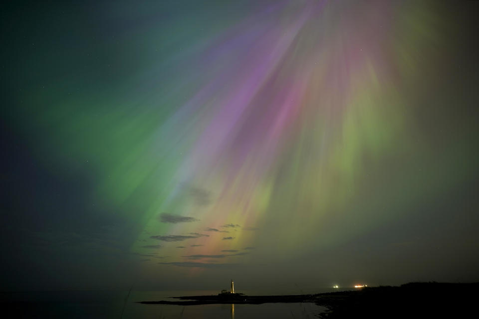 The aurora borealis, also known as the northern lights, glow on the horizon at St Mary's Lighthouse in Whitley Bay on England's Northeast Coast, May 10, 2024. / Credit: Owen Humphreys/PA Images via Getty Images