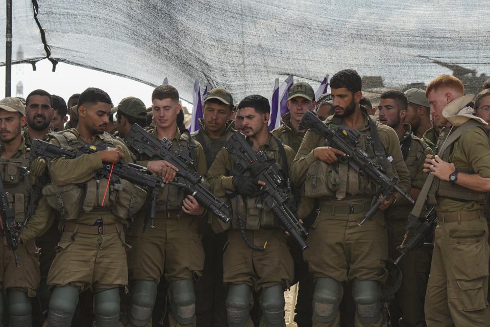 Israeli soldiers listen to Israel's Defense Minister Yoav Gallant, during his visit to a staging area near the border with the Gaza Strip in southern Israel, Thursday, Oct. 19, 2023. (AP Photo/Tsafrir Abayov)