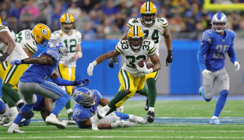 Green Bay Packers running back Aaron Jones runs by Detroit Lions defensive end Romeo Okwara (95) during the second half Sunday, Dec. 29, 2019 at Ford Field.