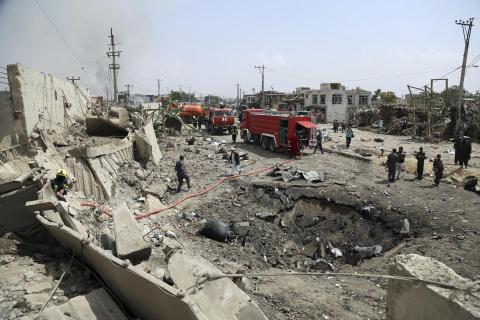 Security forces stand next to a crater caused by Monday's suicide bomb attack in Kabul, Afghanistan, Tuesday, Sept. 3, 2019. (AP Photo/Rahmat Gul)