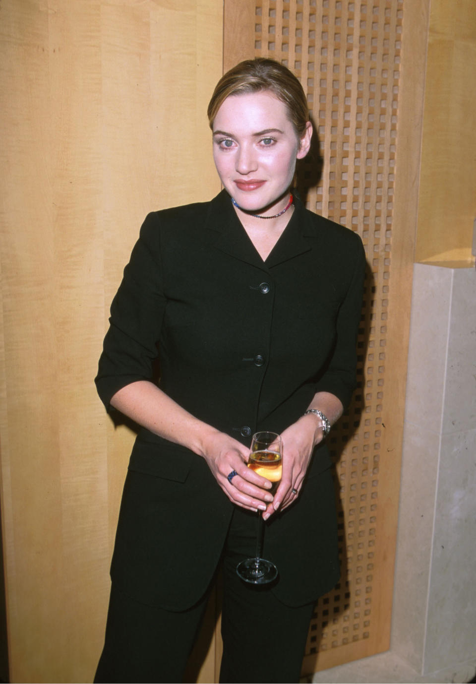 Woman in a black suit holding a glass at an event