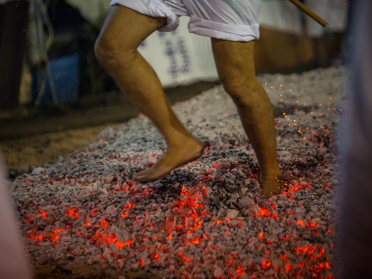 A man walks over hot coals in Thailand.