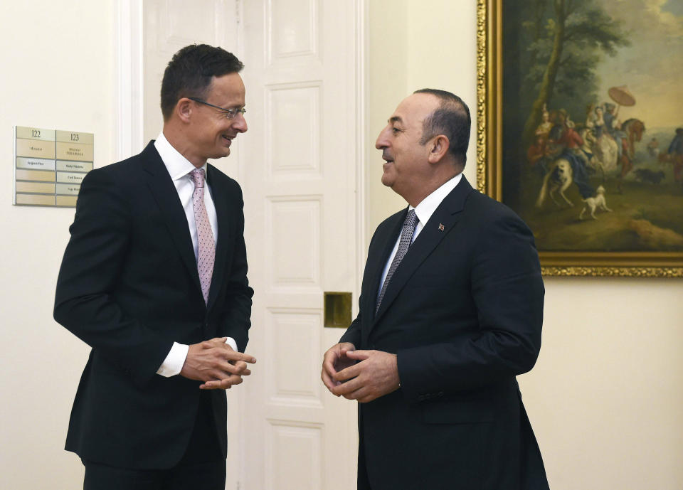 Hungarian Minister of Foreign Affairs and Trade Peter Szijjarto, left, welcomes Turkish Foreign Minister Mevlut Cavusoglu at the Ministry of Foreign Affairs and Trade in Budapest, Hungary, Friday, May 3, 2019. (Noemi Bruzak/MTI via AP)