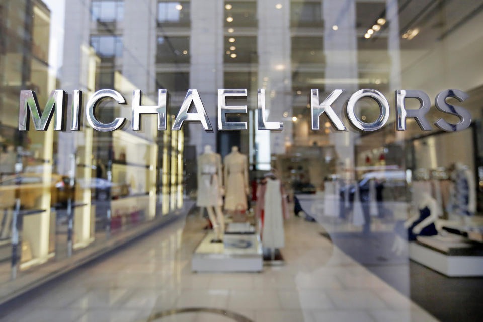 FILE- In this May 31, 2017, file photo the Michael Kors name adorns his store on Madison Avenue, in New York. Michael Kors is buying the Italian fashion house Gianni Versace in a deal worth more than $2 billion in a hard charge into the world of high end fashion. The deal announced Tuesday, Sept. 25, 2018, follows the New York handbag maker’s $1.35 billion acquisition last year of the high-end shoemaker Jimmy Choo. (AP Photo/Richard Drew, File)