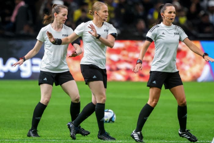 Calentando junto a sus dos asistentes, también mujeres