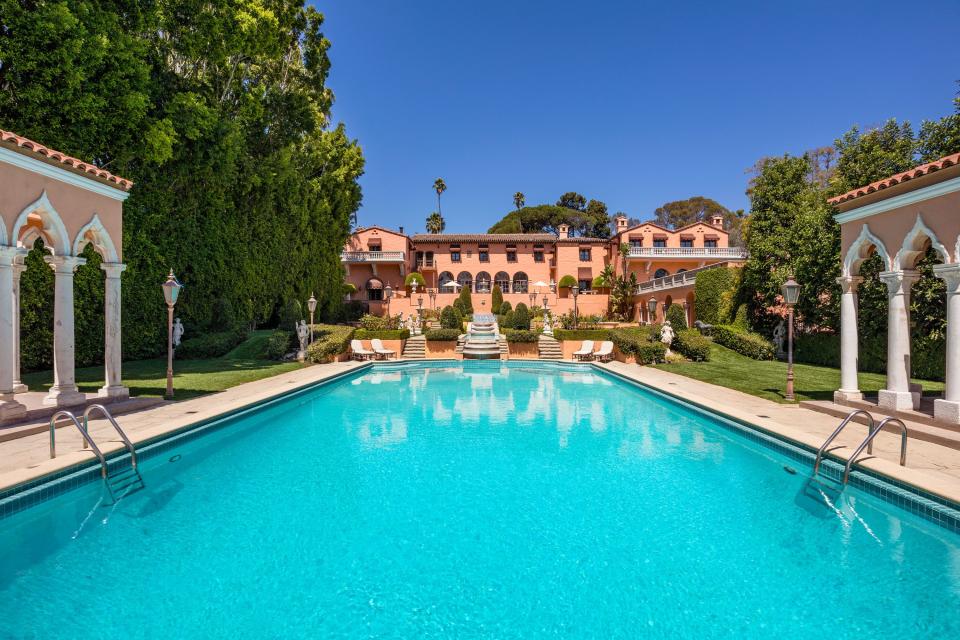 <p>The legendary Beverly House mansion has officially hit the market for $135 million. Originally owned by publishing magnate <a rel="nofollow noopener" href="https://www.townandcountrymag.com/leisure/news/g2264/william-randolph-hearst-penthouse/" target="_blank" data-ylk="slk:William Randolph Hearst;elm:context_link;itc:0;sec:content-canvas" class="link ">William Randolph Hearst</a>, the home was featured in iconic scenes from <em>The Godfather</em> and <em>The Bodyguard</em>, and was the home where <a rel="nofollow noopener" href="https://www.townandcountrymag.com/the-scene/weddings/g870/jackie-jfk-wedding-photos/" target="_blank" data-ylk="slk:JFK;elm:context_link;itc:0;sec:content-canvas" class="link ">JFK</a> and Jackie Kennedy spent their honeymoon. It also became the West Coast presidential election headquarters for JFK’s presidential campaign in the '60s. <br><br>Designed by acclaimed architect Gordon Kaufmann in 1927, the estate features H-form architecture, complete with expansive balconies, long colonnades, and arched floor-to-ceiling windows. The home is overflowing with luxury amenities, and includes 19 bedrooms, 29 bathrooms, and an Olympic-sized swimming pool. The property, which <a rel="nofollow noopener" href="https://www.toptenrealestatedeals.com/homes/weekly-ten-best-home-deals/2018/10-08-2018/1/" target="_blank" data-ylk="slk:Top Ten Real Estate;elm:context_link;itc:0;sec:content-canvas" class="link ">Top Ten Real Estate </a>called a “quintessential emblem of Hollywood’s Golden Era,” is set on its own promontory and is located only three blocks away from Sunset Boulevard and The Beverly Hills Hotel. <a rel="nofollow noopener" href="https://www.jademillsestates.com/property/1011-n-beverly-drive-beverly-hills-ca-90210-us" target="_blank" data-ylk="slk:Jade Mills;elm:context_link;itc:0;sec:content-canvas" class="link ">Jade Mills</a> of Coldwell Banker in Beverly Hills has the listing. </p>