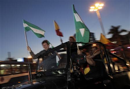 Supporters wave party flags (green and white) of Johnny Araya, presidential candidate of the ruling National Liberation Party (PLN), while travelling in a vehicle during the presidential election run-off in San Jose April 6, 2014. REUTERS/Juan Carlos Ulate