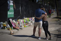 FILE - Two people who knew an unidentified victim of a fatal incident at the Houston Astroworld concert embrace at a memorial on Sunday, Nov. 7, 2021. The family of two close friends from suburban Chicago who were killed at the Astroworld concert in Houston this month have filed wrongful death lawsuits against rapper Travis Scott, the Live Nation entertainment company and others. (AP Photo/Robert Bumsted, File)