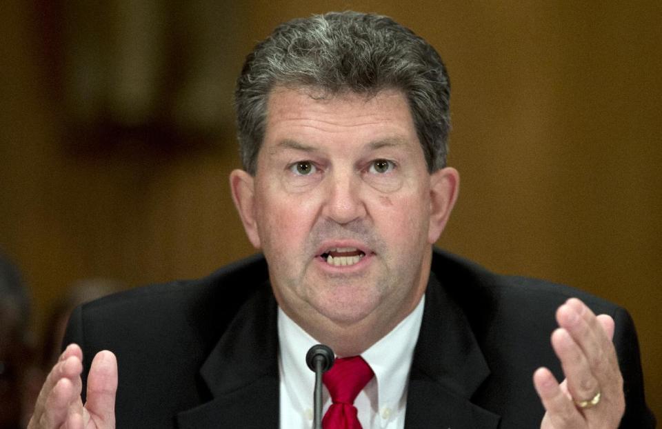 FILE - This Sept. 19, 2013 file photo shows Postmaster General Patrick Donahoe testifying on Capitol Hill in Washington. The opening of Postal Service retail centers in dozens of Staples stores around the country is being met with threats of protests and boycotts by the agency’s unions. The new outlets are staffed by Staples employees, not postal workers, and labor officials say that move replaces good-paying union jobs with low-wage, nonunion workers. (AP Photo/Carolyn Kaster, File)