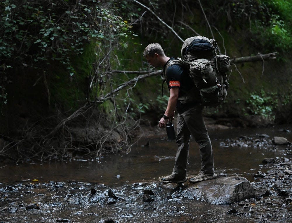 A Special Forces candidate assigned to the U.S. Army John F. Kennedy Special Warfare Center and School walks across a small stream Sept. 16, 2023, during the final phase of field training known as Robin Sage near Pittsboro.