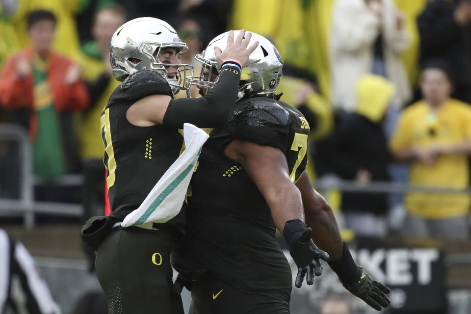 Oregon quarterback Bo Nix, left, celebrates with with offensive lineman Steven Jones after scoring a touchdown during the first half of an NCAA football game against California, Saturday, Nov. 4, 2023, in Eugene, Ore. (AP Photo/Amanda Loman)