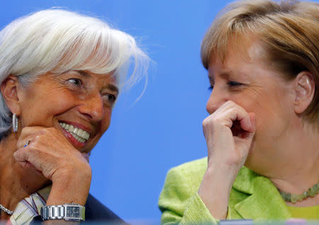 FILE PHOTO: German Chancellor Angela Merkel (R) and Managing Director of the IMF Christine Lagarde attend a news conference following a meeting of the heads of international economy and finance organisations at the Chancellery in Berlin, Germany, April 10, 2017. REUTERS/Hannibal Hanschke/File Photo