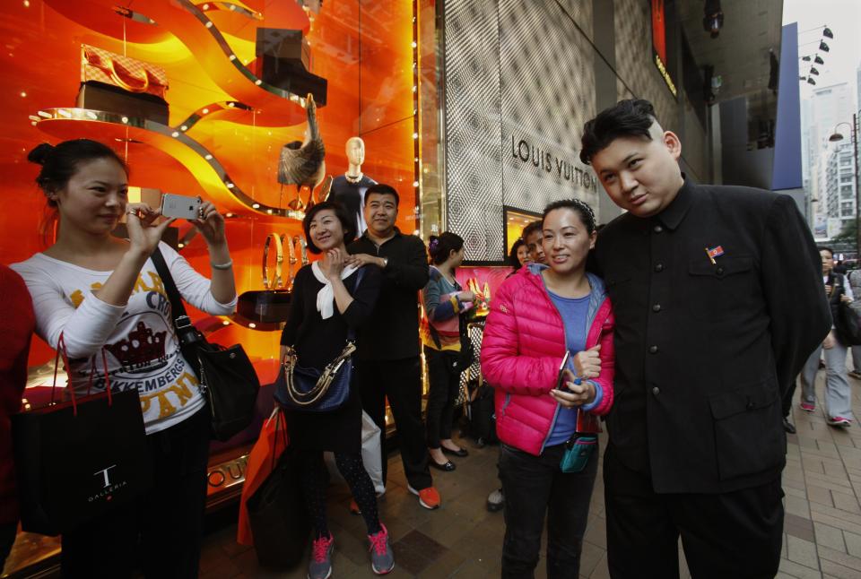 Howard poses with a Chinese tourist as he appears as a Kim Jong-un lookalike on a street at Hong Kong's Tsim Sha Tsui shopping district