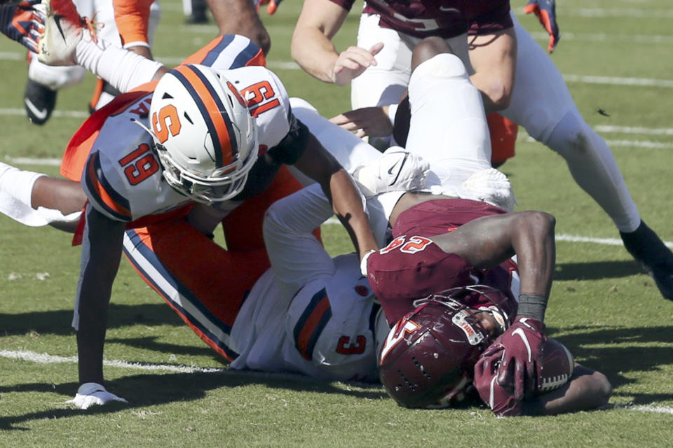 Virginia Tech running back Malachi Thomas (24) scores a touchdown past Syracuse's Mikel Jones (3) and Rob Hanna (19) during the first half of an NCAA college football game in Blacksburg Va., Saturday, Oct. 23 2021. (Matt Gentry/The Roanoke Times via AP)