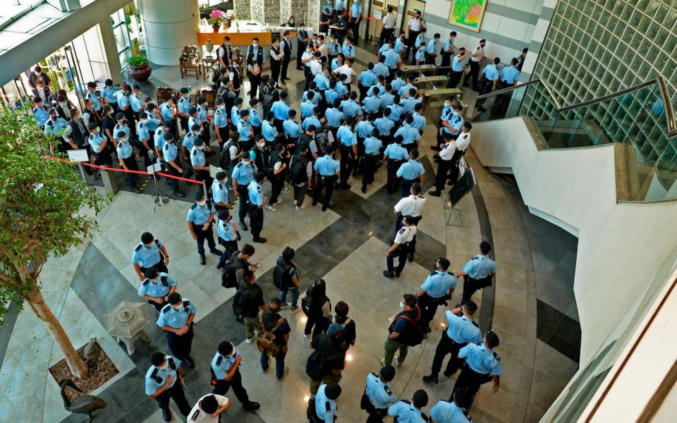 Police officers gather at the lobby of headquarters of Apple Daily in Hong Kong Thursday - Apple Daily