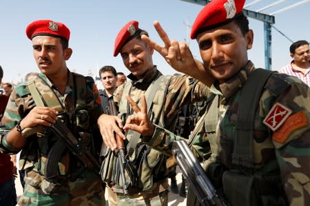 Syrian army member makes a V sign at the Iraqi-Syrian border