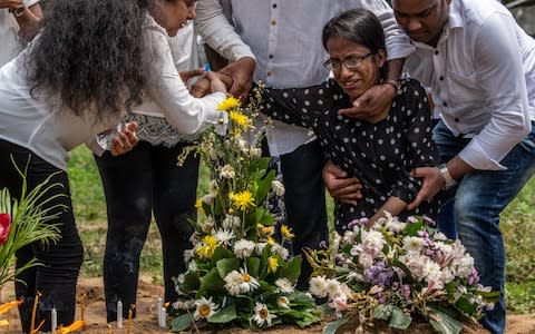 A woman mourns her mother, killed in the St Sebastian's church - Credit: Carl Court&nbsp;/Getty Images