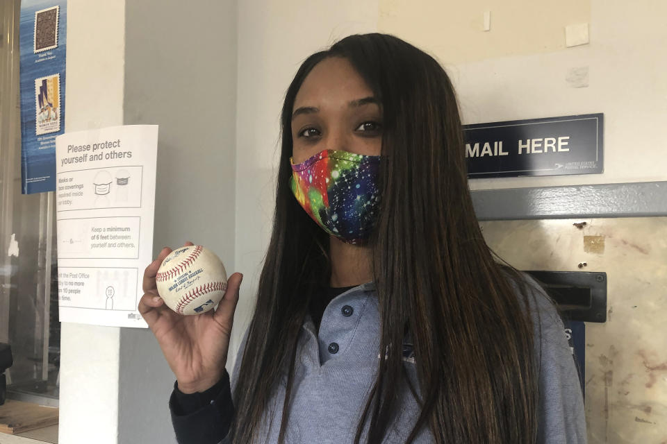 U.S. Postal Service worker Tionne Eitz holds a foul ball gift on Monday, Sept. 21, 2020, in Alameda, Calif. (AP Photo/Janie McCauley)