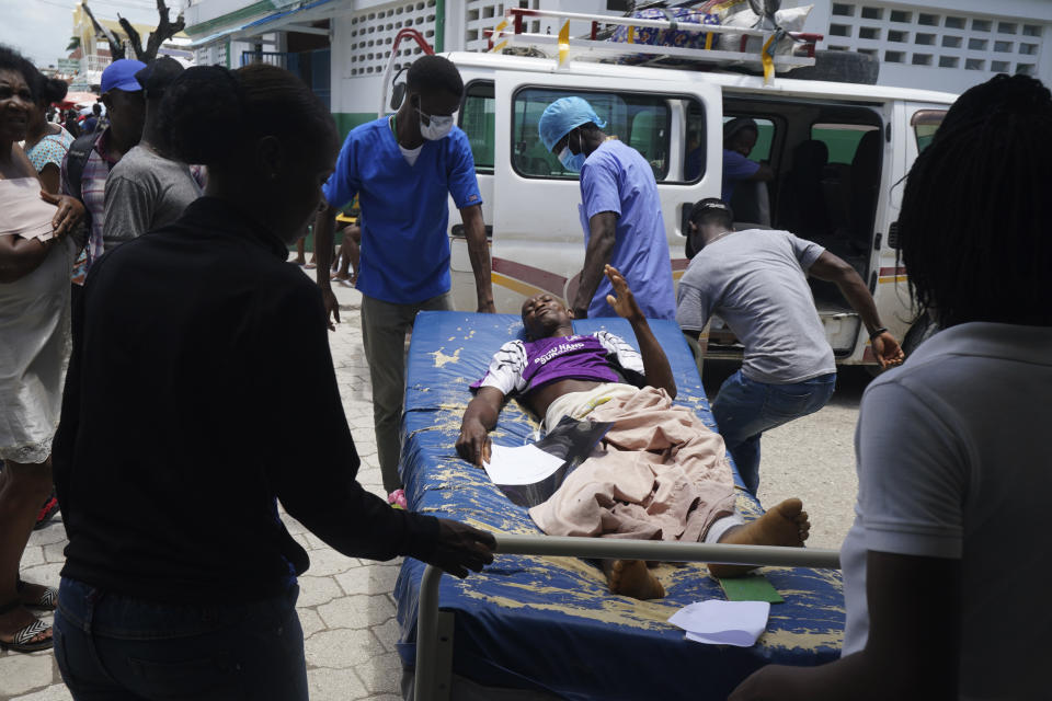 A person who was injured in the earthquake is carried away after getting an x-ray at the General Hospital in Les Cayes, Haiti, Wednesday, Aug. 18, 2021. (AP Photo/Fernando Llano)