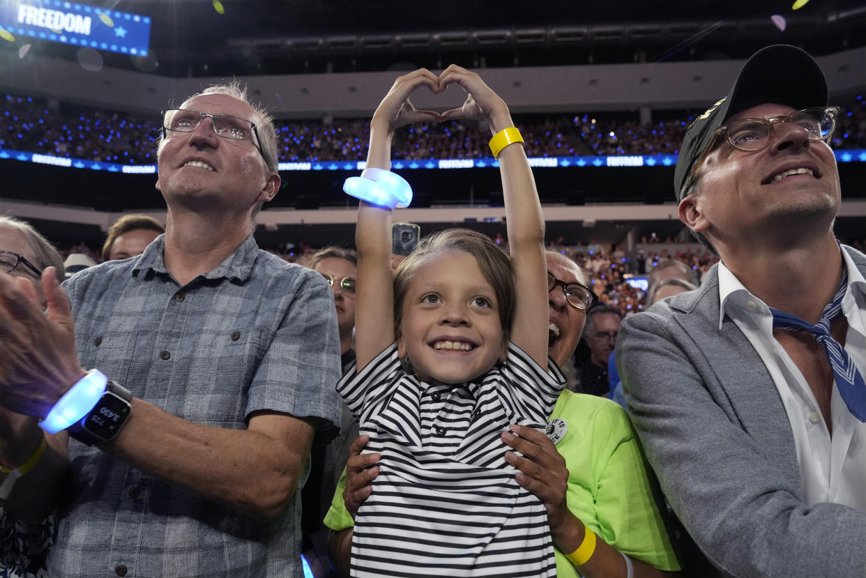 Ashbey Beasley and her son Beau, 8, watch Kamala Harris speak during a campaign rally in Milwaukee on Tuesday.