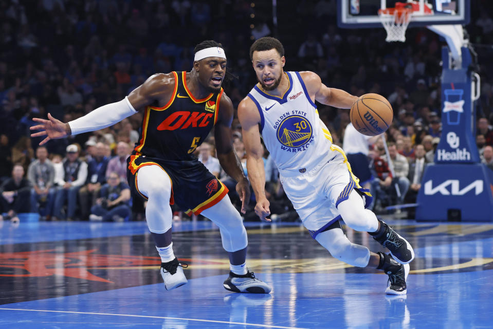 Golden State Warriors guard Stephen Curry (30) drives as Oklahoma City Thunder guard Luguentz Dort (5) defends during the second half of an NBA in-season tournament basketball game Friday, Nov. 3, 2023, in Oklahoma City. (AP Photo/Nate Billings)